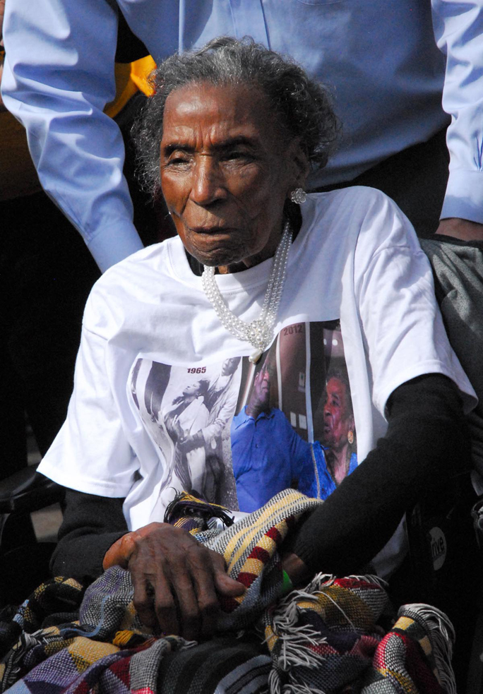 Amelia Boynton-Robinson, known affectionately as Miss Boynton and the queen mother of the civil rights movement, is escorted across the bridge.-Photo by Katie Gavenus