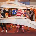 HoWL Skits ’n Scats crew bursts through a banner during a flashmob at the Homer Outdoor Film Festival on Saturday.