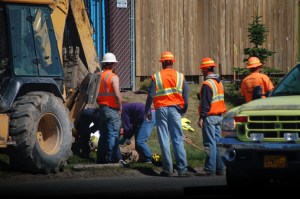 Homer Volunteer Fire Department emergency medical technicians work on an injured laborer at the gas line extension project on the Sterling Highway near Greatland Street at about 2:15 p.m. July 19.-Photo by Michael Armstrong, Homer News
