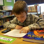Chapman student Tyson Overson self-assesses his fluency level by using an iPod to record himself reading and then playing it back.-Photos by McKibben Jackinsky, Homer News