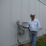 Enstar service technician James Merrow installs the meter on the 119 Fairview Ave. house.-Photo provided