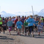 With sunny skies overhead, runners cross the starting line of the annual 5k Migration Run. -McKibben Jackinsky, Homer News