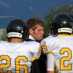 Voznesenka Head Coach Justin Zank huddles with the Cougars during Friday’s game against the Valdez Buccaneers. Shown with Zank are Kiril Zanarov, 26, and Gavril Kalugin, 24.-Photo by McKibben Jackinsky, Homer News