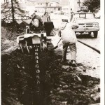 HEA crew puts in underground power lines in 1972 in Seldovia.  Jack Alexander is on the equipment and Spud Dillon works with the shovel.-Photo courtesy of HEA