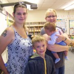 Now in the first grade, Aiden Clark, center, pays a visit to his kindergarten teacher, Jeri McLean, during Paul Banks Elementary School’s meet-your-teacher event on Monday. With Aiden is his mother, Andrea, and 2-month-old brother, Jace, held by McLean.-Photo by McKibben Jackinsky, Homer News