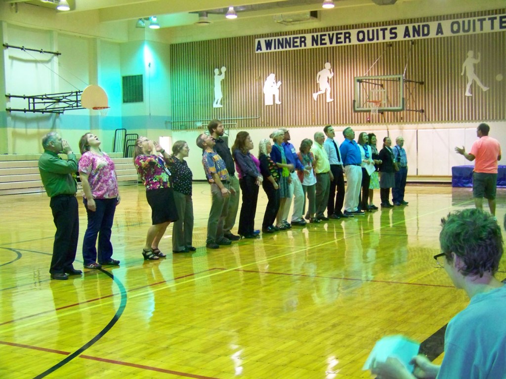 Homer Middle School faculty and staff, led by Tim Daugharty, show students how to do the Husky howl at a first-day assembly on Tuesday.-Photo by McKibben Jackinsky, Homer News