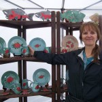 Sally Powell of Peter’s Creek Pottery shows off her salmon patterns.-Photo by McKibben Jackinsky, Homer News