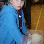 Kya Stokes, first grade, demonstrates the class project researching how it is polar bears manage to stay warm when swimming in icy water.-Photo by McKIbben Jackinsky, Homer News