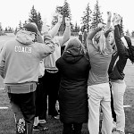 At right, players huddle for the end-of-practice team cheer.-Photo by Lindsay Olsen