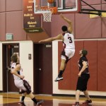 Nikolaevsk Warrior Jaruby Nelson, 3, is head and shoulders above alumni competitor Jonah Yakunin. Also playing for the Warriors is Felemon Molodih, 33. -Photo by McKibben Jackinsky, Homer News