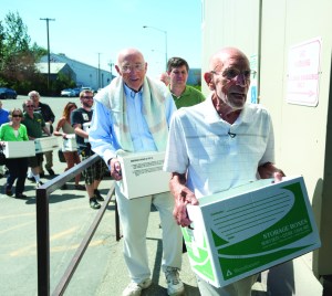 Long-time Alaskans Vic Fischer and Jack Roderick lead a group of Vote Yes — Repeal The Giveaway committee members into the Division of Elections offices July 13. The group collected 50,000 signatures from Alaskans wishing to repeal SB 21.