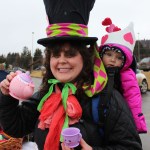Tiana Hopper and her backpack buddy, Malia, offer a cup of imaginary tea from the Imagination Library parade float. -Photo by McKibben Jackinsky, Homer News