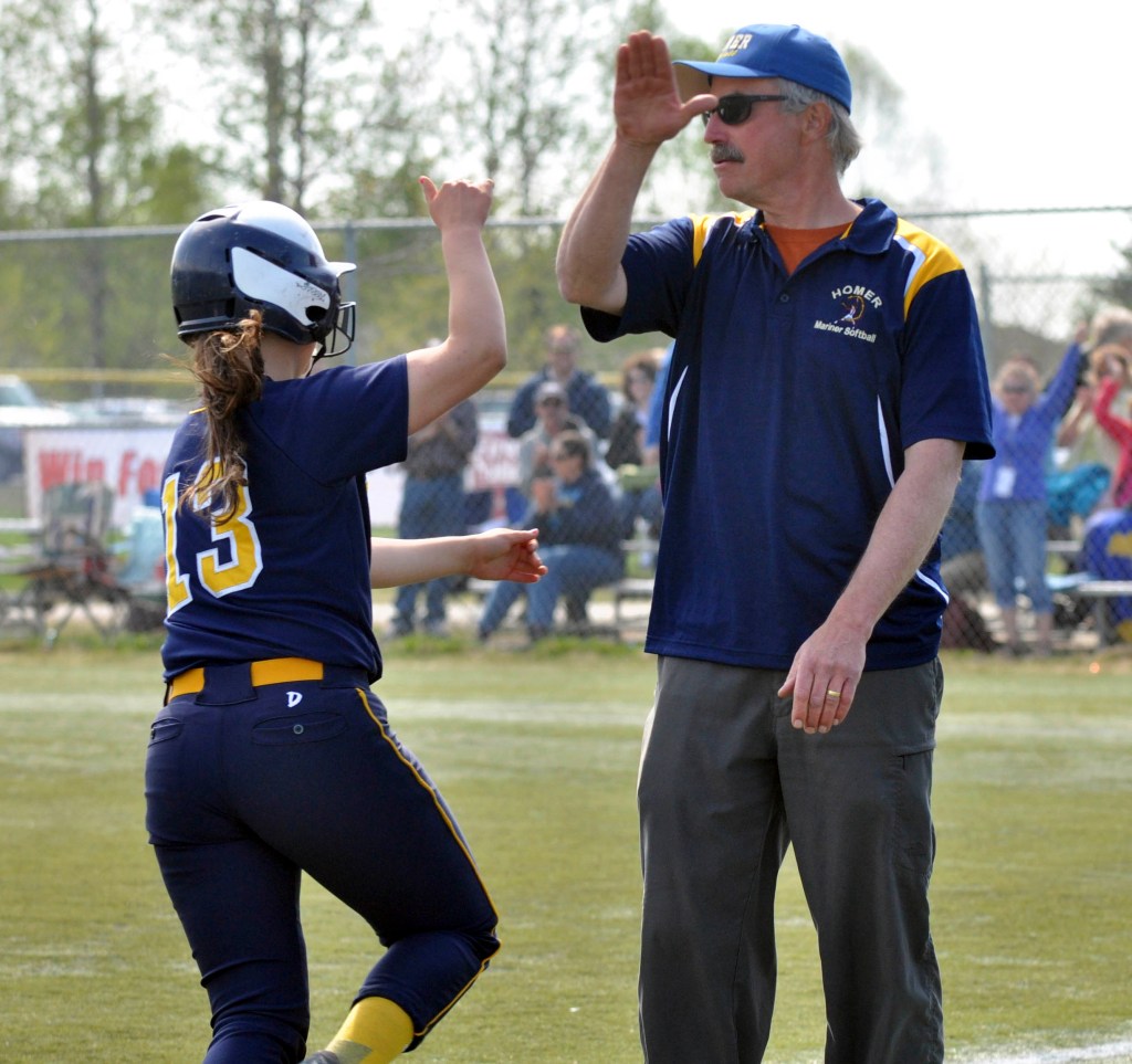 Homer Head Softball Coach Bill Bell high fives senior Miranda Beach as she rounds third base after hitting a home run against Ketchikan in the first round of the small schools state softball tournament Friday, May 31. -Photo by Mike Nesper/Morris News Service - Alaska
