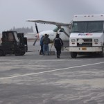 Workers set concrete blocks on the tarmac to tie down a FedEx plan at the Homer Airport.-Photo by McKibben Jackinsky, Homer News