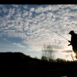 In this May 28, 2011, photo, the sun rises behind Steve Rinker early on a Saturday as he fishes the Ninilchik River for king salmon on the ceremonial start of the Kenai Peninsula sport fishing season. Early run fishing for kings in May and June on the Kenai River was closed in 2013 as a record-low return was observed and the minimum escapement goal was not met. -Peninsula Clarion file photo