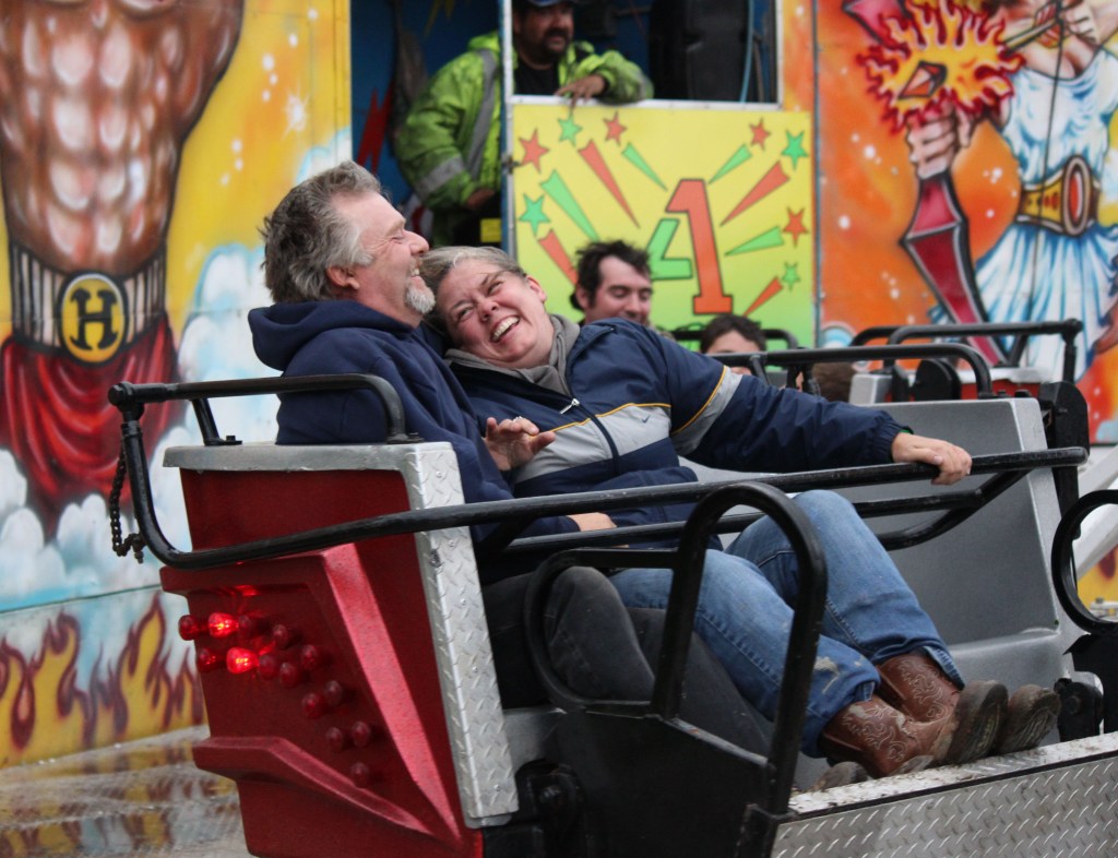 Ray Rodeheauer and Suzanne Lagasse of Soldotna get some laughs riding the Sizzler at the Kenai Peninsula Fair carnival on Saturday night.-Photo by McKibben Jackinsky, Homer News