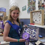 Kenai Peninsula Fair Queen Miranda Martin of Homer shows off the division champion ribbon she won for her mosaic. -Photo by McKibben Jackinsky; Homer News