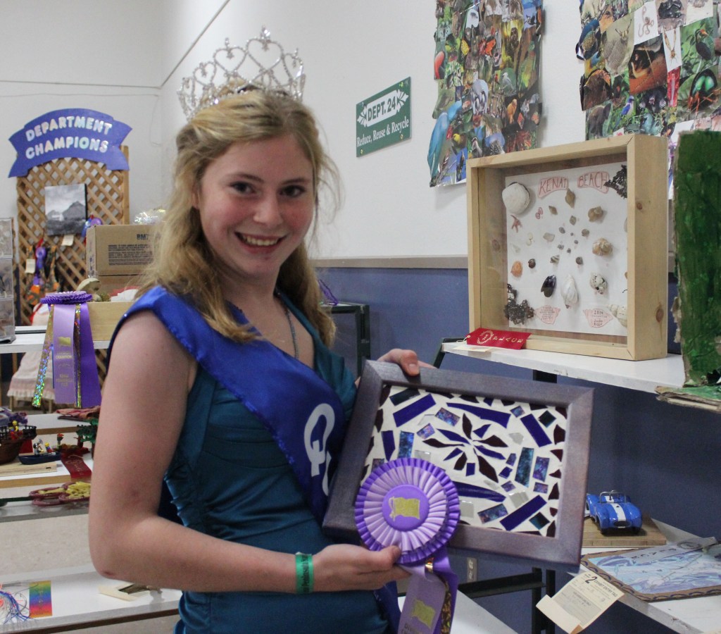 Kenai Peninsula Fair Queen Miranda Martin of Homer shows off the division champion ribbon she won for her mosaic. -Photo by McKibben Jackinsky; Homer News