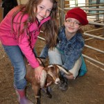 Sisters Angela and Aubrey Duncan of Sterling show off their blue-ribbon goat, Becky, at the Kenai Peninsula Fair.-Photo by McKibben Jackinsky, Homer News
