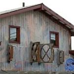 In this photo from 2006, the old Club Bar sign painted by Brad Hughes can be seen behind the posts for the Alice's Champagne Palace sign. The blue paint was added when the Alice's sign was put up, but faded to reveal the original mural. The female and male nudes can be seen to the left and right of the sign. The building and mural has since been painted over.-Homer News file photo