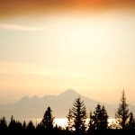 The sun sets through smoke from the Funny River Horse Trail fire over Mount Iliamna on Tuesday night. An inversion layer caused smoke to settle over Homer early Tuesday, but broke up later that night. The haze turned the sun orange red as it moved behind the smoke.-Photo by Michael Armstrong, Homer News