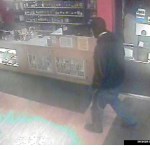 This photo taken by security cameras at the Grog Shop shows a side view of the robber entering the store on Dec. 26 carrying what appears to be a Snakecharmer .410-caliber shotgun.