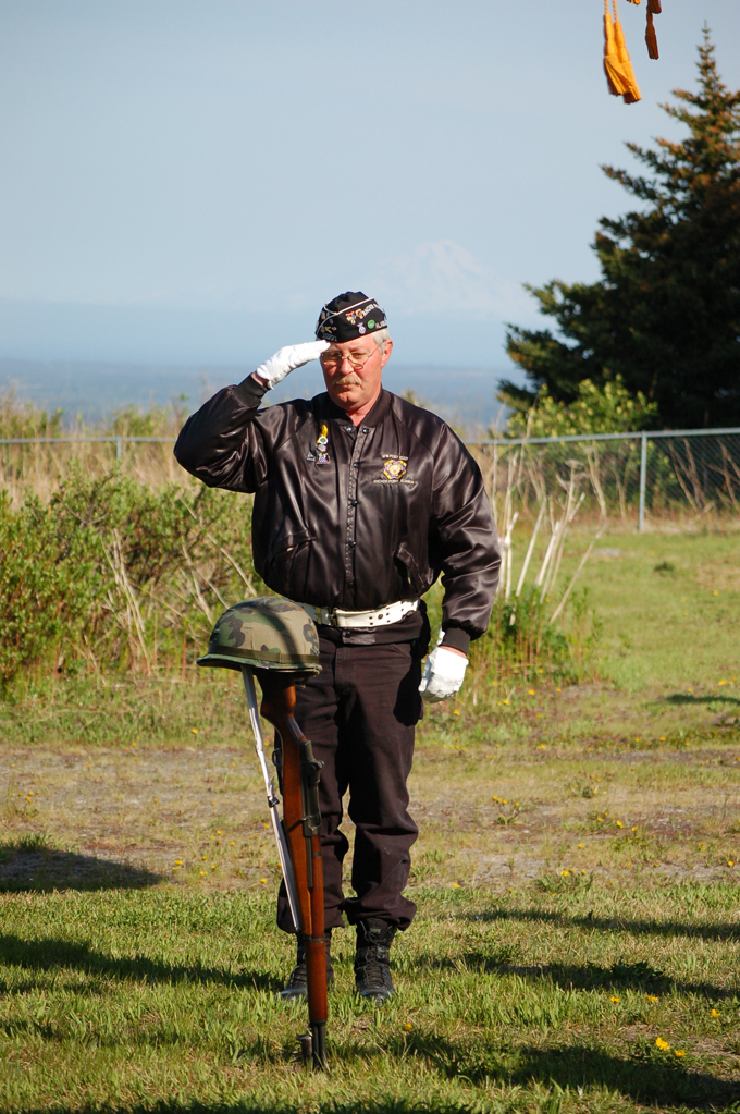 Eric Henley of the Anchor Point Veterans of Foreign Wars Auxiliary salutes a rifle and helmet symbolizing America’s war dead during Memorial Day ceremonies at Hickerson Memorial Cemetery.-Photo by Michael Armstrong, Homer News