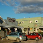 AJ’s, left, and Bunnell Street Arts Center, also known as the Old Inlet Trading Post, are two of the original buildings on Bunnell Avenue dating back to the 1930s. Maura’s Cafe is next to the arts center.-Photo by Michael Armstrong, Homer News