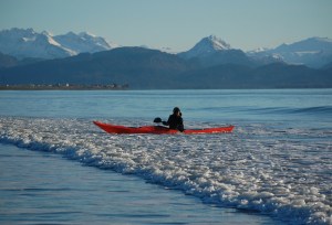 Kim McNett kayaks in a gentle surf off the Homer Spit last week. McNett and partner Bjorn Olsen took advantage of a sunny day to practice their kayak skills.-Photo by Michael Armstrong, Homer News