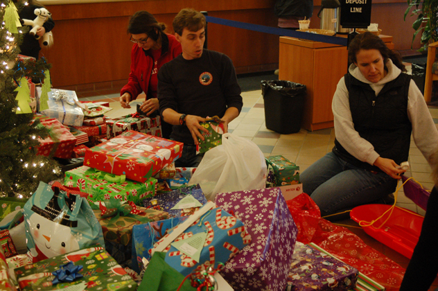 Emerson Coppo carries a gift from the Share the Spirit gift tree at Wells Fargo-Photos by Michael Armstrong and McKibben Jackinsky, Homer News; and Derotha Ferraro