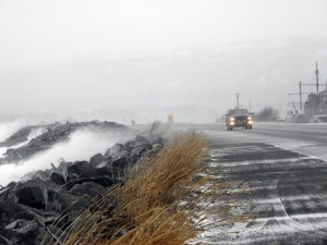 A truck drives past waves crashing on the Homer Spit Road last Friday afternoon as the high tide comes in. Winds were 35 to 40 mph with seas up to 7 feet on a 17.6-foot high tide. This weekend’s forecast calls for better weather, with sunshine and temperatures in the low 30s and high 20s.-Photo by Michael Armstrong, Homer News