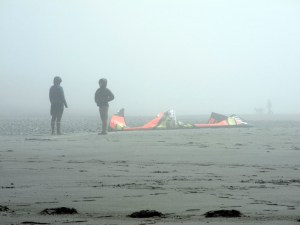 Beach walkers wait for kite surfers to hit the waves last Saturday as fog shrouds the Homer Spit during KiteFest.-Photo by Michael Armstrong, Homer News