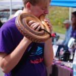 Axel Gillam tries out a didgeridoo at the Mermaid Imports booth at the HCOA Street Faire. He’s a member of Williwaw Marimba. They played at the Homer Farmers Market earlier that day.-Photo by Michael Armstrong, Homer News