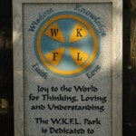 The plaque on the rock at WKFL Park explains the meaning of the initials: Wisdom, Knowledge, Faith and Love.-Photo by Michael Armstrong, Homer News