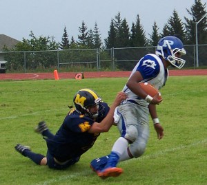 Mariner Sheldon Hutt, 7, tries to put a stop to the Palmer Moose’s 48-0 victory on Saturday.-Photo by McKibben Jackinsky, Homer News
