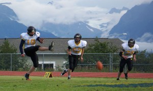 Voznesenka Cougar Dennis Martishev, 18, kicks the ball into play at the Cougar’s homecoming game against the Seward Seahawks on Saturday. Also pictured are Markian Polushkin, 62, and Michael Kusnetsov, 75.-Photos by McKibben Jackinsky, Homer News
