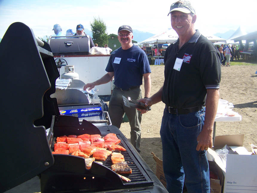 Homer Harbormaster Bryan Hawkins and Homer City Council member Bryan Zak grill food at the picnic.-Photo by McKibben Jackinsky, Homer News