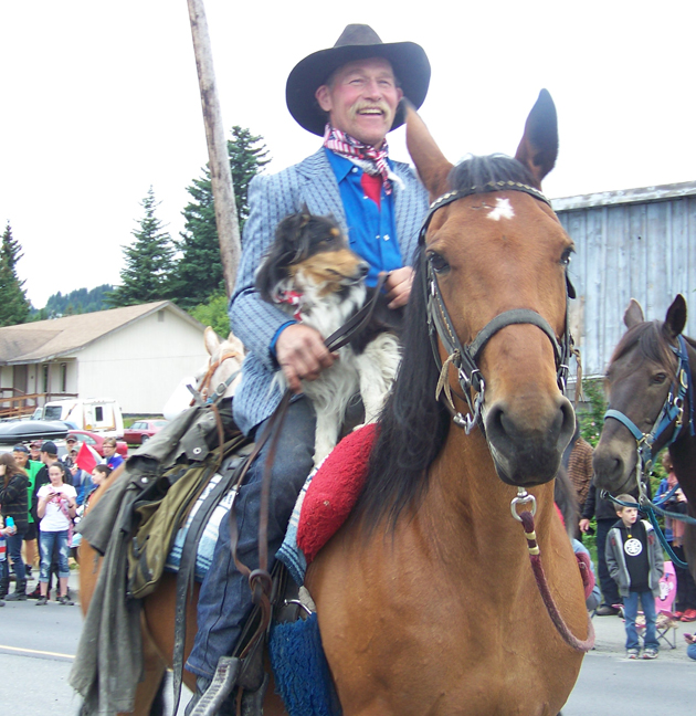 Alex and Adrienne Sweeney, owners of the Driftwood Inn in Homer’s Old Town, give a red-white-and-blue nod to the past and present in the July Fourth parade. -Photo by McKibben Jackinsky, Homer News