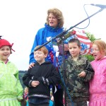 U.S. Sen. Lisa Murkowski receives flowers from Seldovia Village Tribe’s Sea Otter Dancers in Seldovia on July Fourth. The dancers are, from left, Helena Waterbury, Noah Glossi, Conner Ca meron and Nevaeh Morrison.-Photo by McKibben Jackinsky, Homer News