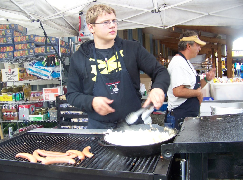 Bernard Villa and his dad, Alex, serve a hot meal on a rainy Kenai Peninsula Fair afternoon.-Photo by McKibben Jackinsky, Homer News