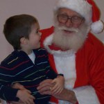 Brennan Steen and Santa share a ho-ho-ho at the Pratt Museum on Saturday.-McKibben Jackinsky,  Homer News