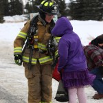 Anchor Point firefighter Lydia Brown hands out candy to youngsters along the parade route.-Photo by McKibben Jackinsky, Homer News
