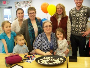 Special Olympic athlete Kinna Ledger, center, celebrates her Winter World Games medal with (back row from left) sister Paulina Baker, mother Susie Ledger, Homer Senior Citizens executive director Keren Kelley; and (front row from left) niece Alinna Baker, nephew J. J. Baker, and niece Larissa Baker.