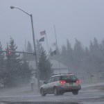 Flags snap and snow swirls as winds increase around noon on Friday.