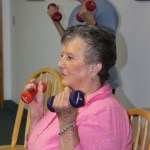 Margaret Lau, standing, and Nancy Smith focus on doing curls with hand weights.-Photo by McKibben Jackinsky, Homer News