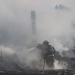 Firefighters from Kachemak Emergency Services, Homer Volunteer Fire Department and Anchor Point Fire and Emergency Medical Services work through the morning to ensure the fire is extinguished.-Photo by McKibben Jackinsky, Homer News