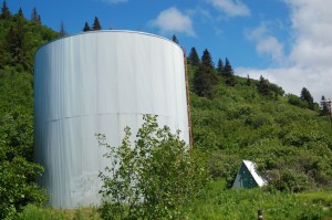 The A-frame building, right, with pressure reduction valve that gives the historic water tank its name is next to the tank at the top of Main Street.-Photo by Michael Armstrong, Homer News
