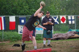 Homer High School student Ian McCormick tosses the stone as judge Ron Campbell of Idaho watches. -Photo by Michael Armstrong, Homer News