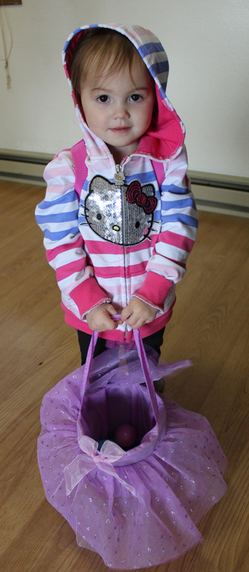 Aryanna Cooper, 2, waits for the signal to fill her frilly basket with eggs.-McKibben Jackinsky
