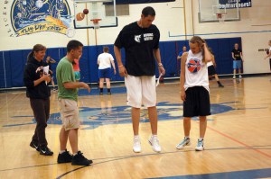Matt Garrison, center, gives Kayla Stafford, right, a Nikolaevsk School basketball player, some pointers at the Bruins Basketball Shooting Clinic last Friday at Homer High School as Bea Klaich, left, and Chris Etzwiler, second from left, watch.-Photo by Michael Armstrong, Homer News